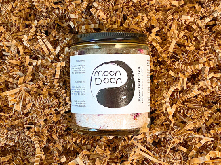glass jar of rose bath salts on brown crinkle paper